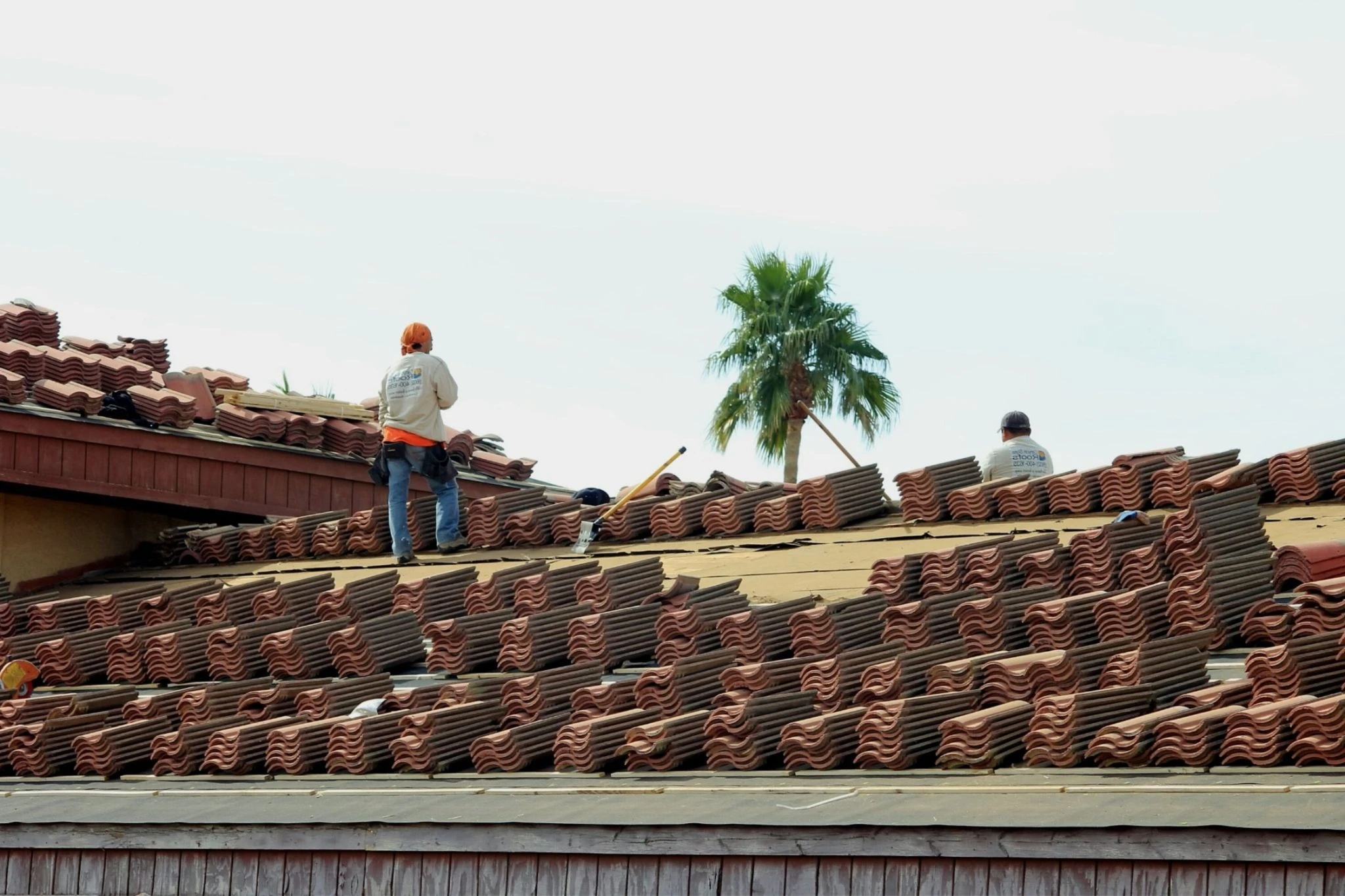 Roofers installing tiles on a residential roof